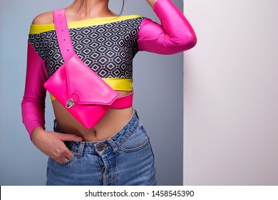 Festival Look Disco Girl, Outfit Details. Female Model 80s Jeans, Colorful Top And Neon Pink Fanny Pack Belt Bag