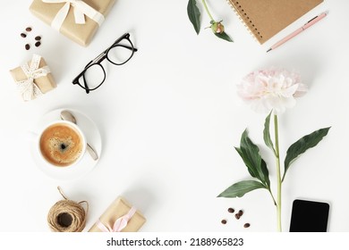 Festive Arrangement: Gift Boxes, Coffee, Notebook, Mobile Phone, Glasses And Flowers On A White Table, Top View, Flat Lay