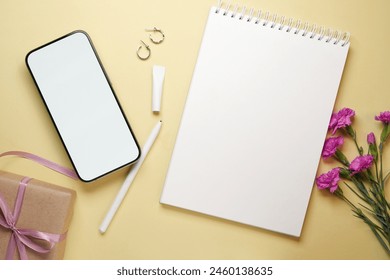 Festive arrangement: gifts with ribbon, notebook with pen, mobile phone and flowers on a pastel table. Top view, flat lay.  - Powered by Shutterstock