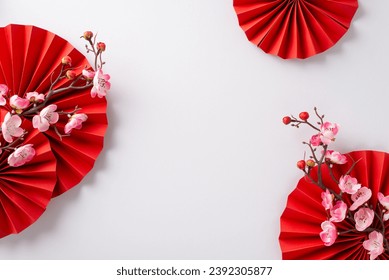 Festive arrangement for Lunar New Year, featuring red fans, and pink sakura flowers. Top view on a white background with ample space for custom messages or advertisements - Powered by Shutterstock