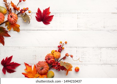 Festive autumn decor from pumpkins, berries and leaves on a white  wooden background. Concept of Thanksgiving day or Halloween. Flat lay autumn composition with copy space.