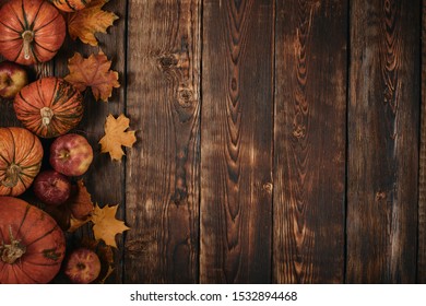Festive autumn still life  with pumpkins, red apples and leaves on dark  wooden background. Top view with copy space. Concept of autumn harvest, happy Thanksgiving  day or Halloween. - Shutterstock ID 1532894468
