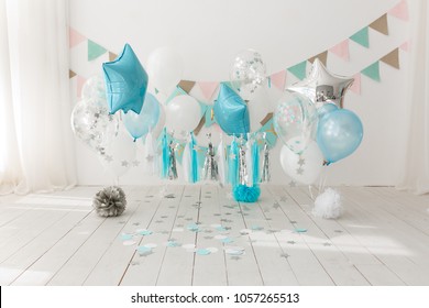 Festive background decoration for birthday celebration with gourmet cake and blue balloons in studio, cake smash first year concept