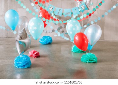 Festive background decoration for birthday celebration, letters saying one and colorful balloons in studio, cake smash first year concept.
