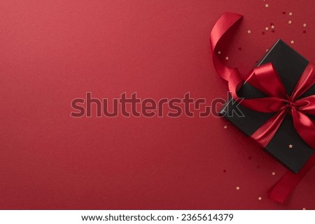 Festive Black Friday surprise! Top view black gift box, adorned with vibrant red ribbon, surrounded by golden star-shaped confetti, set against rich marsala backdrop. Ideal for your Black Friday deals