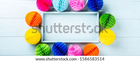 Festive blue background with colorful paper balls. Greeting card concept voor birthday, party, invitation, carnival. Copy space, top view, flat lay, banner
