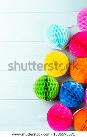 Festive blue background with colorful paper balls. Greeting card concept voor birthday, party, invitation, carnival. Copy space, top view, flat lay.