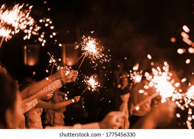 festive burning bright sparklers in the hands of guests at a party - Powered by Shutterstock