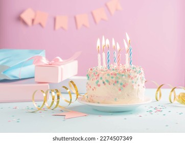 Festive cake with candles on the background of festive pink wall with gifts and flags in serpentine - Powered by Shutterstock
