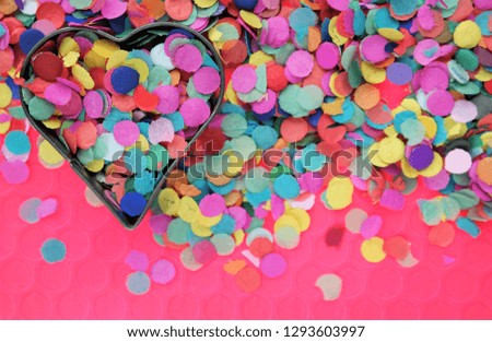 festive carnaval concept with colorful confetti and heart shape. Party background and text space