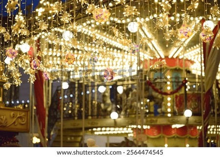 A festive carousel adorned with string lights and hanging ornaments at the Craiova Christmas Market, featuring a golden glow and vibrant holiday decorations.
