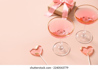 Festive champagne, romantic gift and two pink lollipops on stick on pink background. Valentine's day greeting card. Close up. Copy space. - Powered by Shutterstock