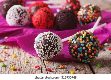 Festive chocolate cake pops with candy sprinkles close-up on the table. horizontal