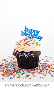 Festive Chocolate Cupcake Topped With Colorful Sprinkles And Happy Birthday Sign On White Background