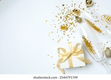 Festive Christmas background with champagne glasses, gift box and confetti, copy space composition - Powered by Shutterstock