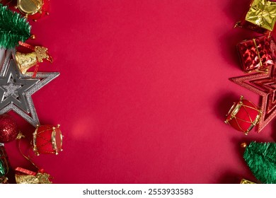 Festive Christmas decorations on bright red background, gifts, baubles, mini tree, stars, bells and drum ornaments - Powered by Shutterstock