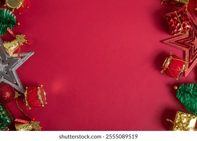 Festive Christmas decorations on bright red background, gifts, baubles, mini tree, stars, bells and drum ornaments - Powered by Shutterstock