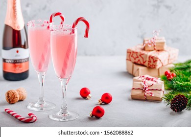 Festive Christmas Drink Peppermint Bark Mimosa Cocktail With Champagne Or Prosecco And Candy Cane On Gray Stone Concrete Background, Copy Space.