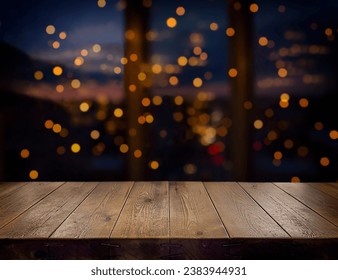 Festive, Christmas, New Year background. Evening. Night. Homely, cozy background. Abstract background. A wooden table on the background of a window with a night view and golden garlands. Bokeh.  - Powered by Shutterstock