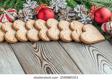 festive christmas and new year background with copy space, fir branches, Christmas decorations, pine cones and gingerbread cookies on a vintage wooden table  - Powered by Shutterstock