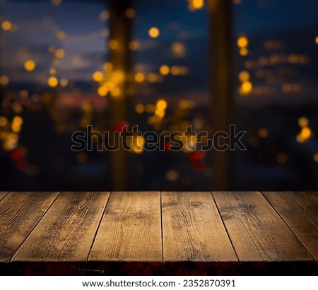 Festive, Christmas, New Year background. Evening. Night. Homely, cozy background. Abstract background. A wooden table on the background of a window with a night view and golden garlands. Bokeh. 