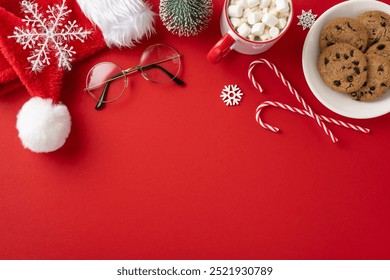 Festive Christmas scene featuring Santa hat, cookies, candy canes, hot chocolate, and snowflake decorations arranged on a vibrant red background - Powered by Shutterstock