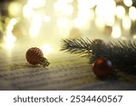 Festive Christmas Scene with Ornaments, Sheet Music, and Pine Branch