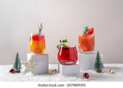 Festive citrus cocktails on podiums. Assortment of fresh Christmas drinks. Pink and red sangria cocktails, pomegranate  jingle and citrus tequila smashy. - Powered by Shutterstock