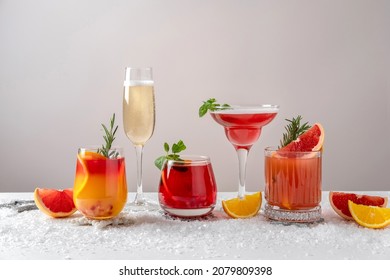 Festive Cocktails With Various Citrus. Assortment Of Alcohol Christmas Drinks. Pink And Red Sangria Cocktails, Champagne, Pomegranate  Jingle And Citrus Tequila Smash.