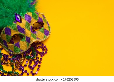 A festive, colorful group of mardi gras or carnivale mask on a yellow background.  Venetian masks.