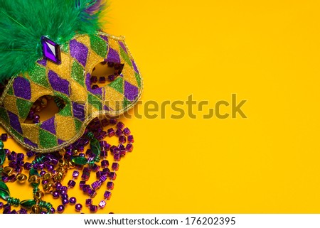 A festive, colorful group of mardi gras or carnivale mask on a yellow background.  Venetian masks.