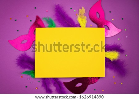 Festive, colorful mardi gras or carnivale mask and accessories over purple background. Party invitation, greeting card, venetian carnivale celebration concept. Flat lay, top view, copy space
