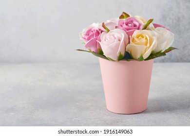 Festive composition with beautiful delicate roses flowers in pink round box on light gray background. Flat lay, copy space.