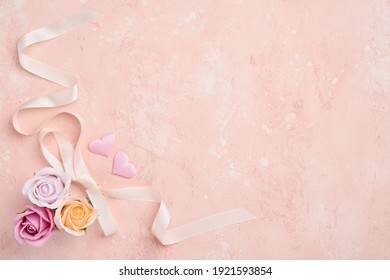 Festive composition with beautiful delicate roses flowers in pink round box on light pink background. Flat lay, copy space. Greeting card.