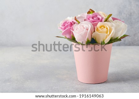 Festive composition with beautiful delicate roses flowers in pink round box on light gray background. Flat lay, copy space.