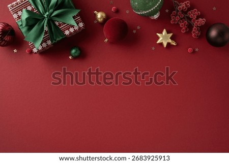 A festive composition featuring a wrapped gift with green ribbon and an array of Christmas ornaments and decorations on a red backdrop, evoking warm holiday cheer and seasonal greeting