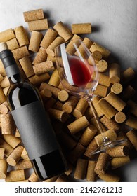 Festive composition. On wine corks is a bottle of red wine and a glass. Close-up. There are no people in the photo. Wine collection, vineyard, wine cellar, tasting, restaurant, hotel, banquet.