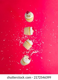 Festive Composition. Small Muffins Decorated With White Cream And Raspberries On A Bright Pink Background With White Powdered Sugar Crumbs. There Are No People In The Photo. Holiday, Birthday.