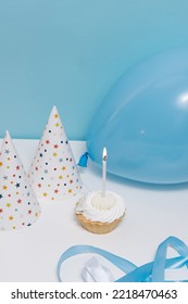 Festive Concert - Balloons, Caps And A Cupcake Stand On A Table On A Blue Isolated Background