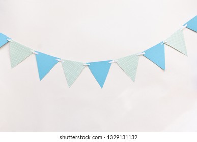 Festive Decor For A Children's Holiday To Smash The Cake Or A Birthday, Baby Shower Boy. Blue Triangular Flags On White Wall