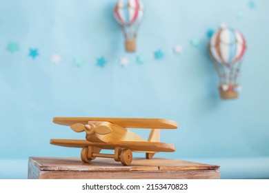 Festive decor. Wooden toy plane on a blue background with hot air balloon toy. Decor for a child's birthday - Powered by Shutterstock