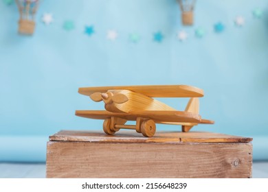 Festive decor. Wooden toy plane on a blue background with hot air balloon toy. Decor for a child's birthday - Powered by Shutterstock