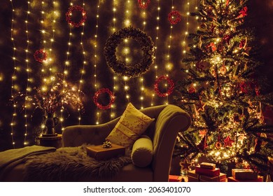 Festive Decorated Home Interior Living Room In With Lot Of String LED Lights, Led Curtains And Pine Cone And Berry Wreaths On Wall, Red Christmas Gifts Under The Tree, Comfortable Canape Sofa Waiting.