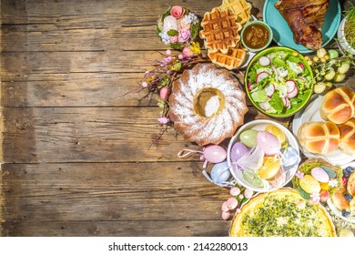 Festive dinner, Easter brunch. Traditional Easter dishes on family home table - baked meat, quiche, spring salad, muffin, colored eggs, hot cross buns