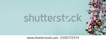 Festive Easter background, chocolate sweets, quail eggs and blooming almond