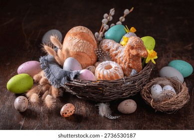 Festive Easter basket with painted eggs, flowers and bread. Easter background with easter eggs and catkins.