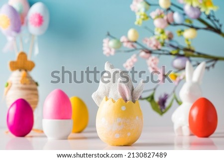 Festive Easter composition with a rabbit in an Easter egg on a floral background