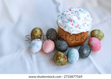 Festive Easter kulich on a light tablecloth with painted eggs, classic Easter symbol.