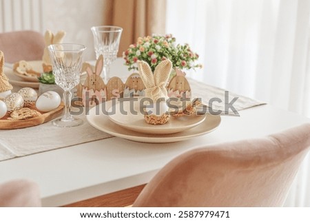 Festive Easter table setting with Easter bunny made from egg and knitted ears. Easter celebration concept