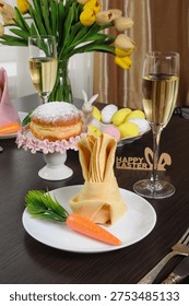Festive Easter table setting with a decoratively folded napkin in the shape of a bunny and carrot